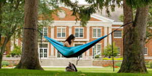 A student in a hammock on campus.