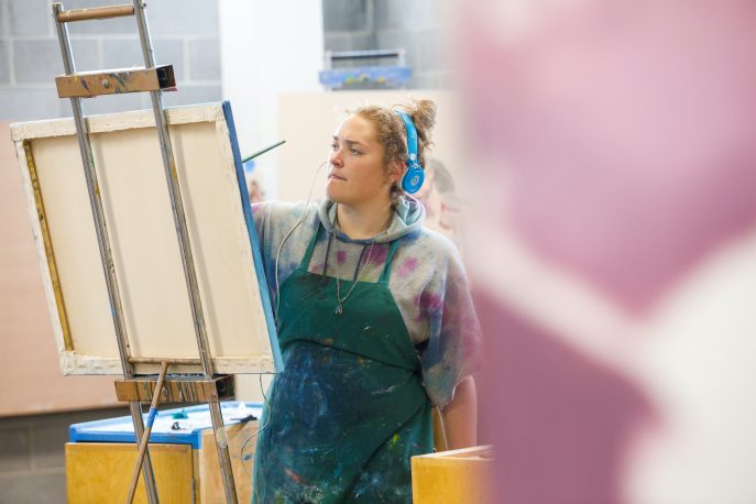 A student working on a canvas in the art studios.