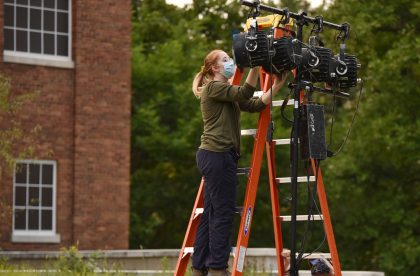 Student outside setting up lighting.