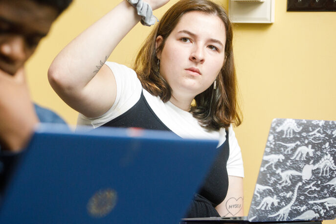 A student raising her hand in class.