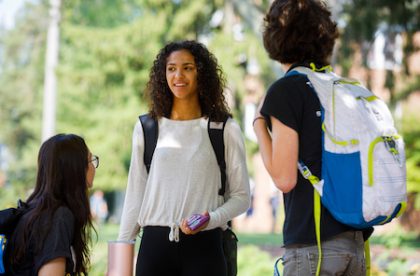 Three Albion College students talking outside on campus