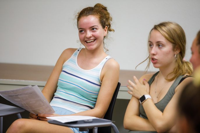 Students in a classroom taking part in a classroom discussion