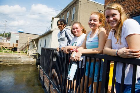 Four Albion College students posing in downtown Albion.