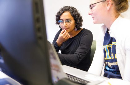 Two students working together on a laptop computer