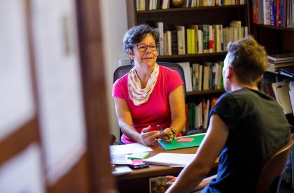 Faculty member speaking with a student in an office