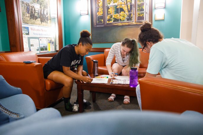Three Albion College students working together in a common area on campus