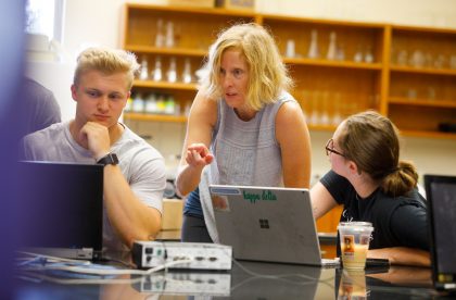 Faculty member working with students in a lab