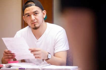 Student holding a piece of paper in a classroom