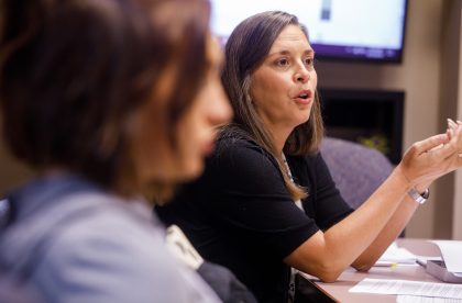 Faculty member addressing students in a classroom setting.