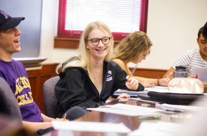 Several students gathered around a table working.