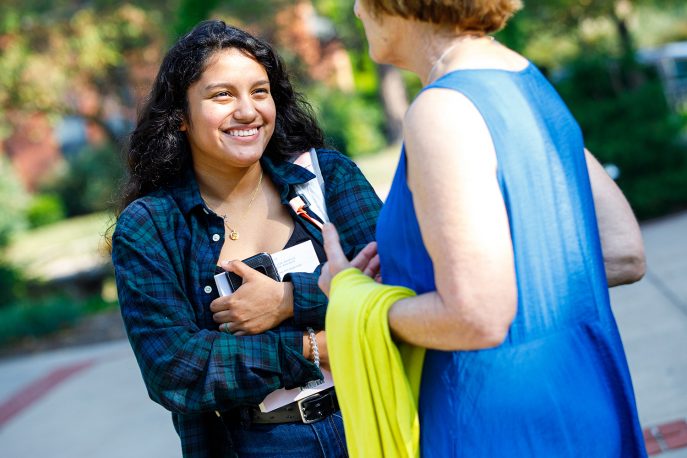 A student and professor in conversation on the Quad.