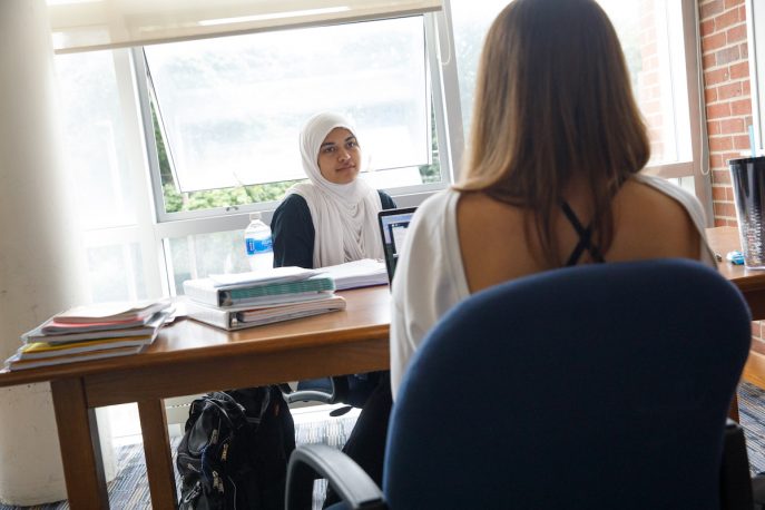 Two Albion College students working around a table.