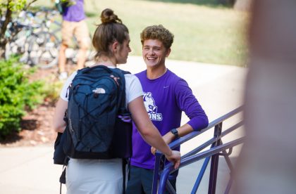 Two students in conversation on the steps of Kresge.