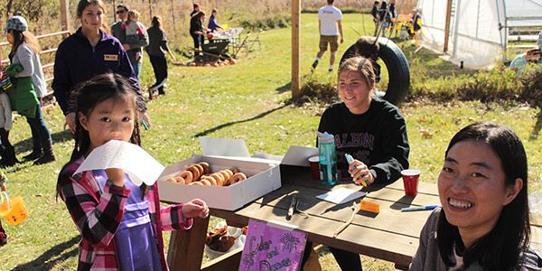 Students sitting at a table selling donuts.