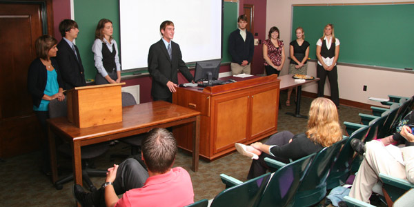 A group of students at the front of a classroom presenting.