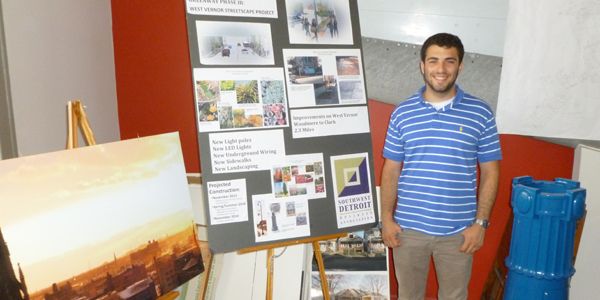 A student standing in front of an academic poster.