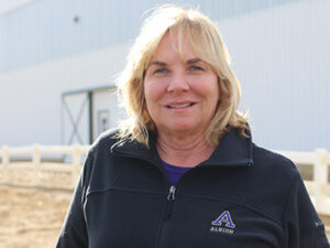 A person standing in front of a barn.