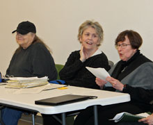 Three people sitting behind a table.