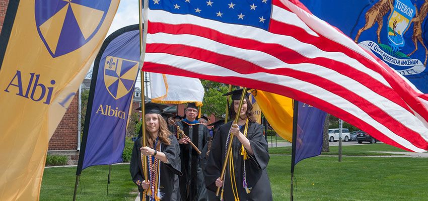 Students in a processional carrying flags.