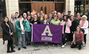 A group of students posing with an Albion flag.