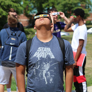 People wearing eclipse glasses looking up.