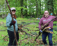 Two students clearing brush.