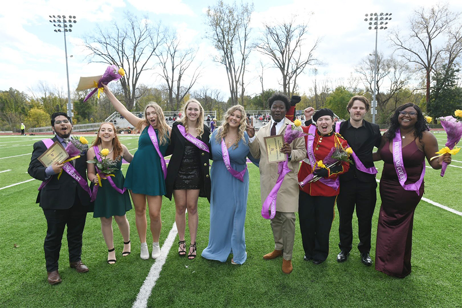 A photo of the Homecoming Court posing on the football field.