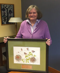 Dale Kennedy posing behind an illustration of house wrens.