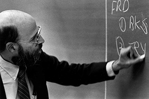 A man writing on a chalkboard.