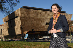 Mallory Fellows Bower stands in front of the National Museum of African American History and Culture.
