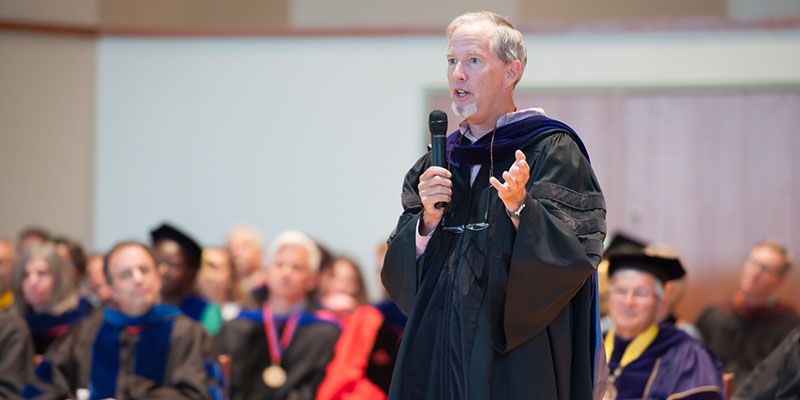 A professor speaking on stage.