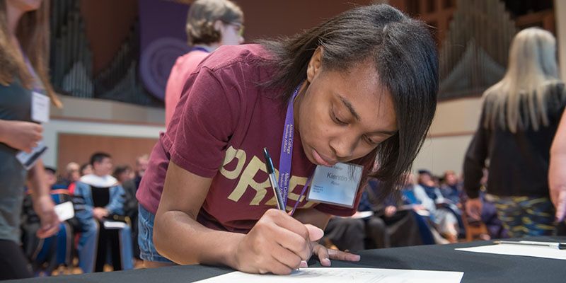 A student signing the class book.