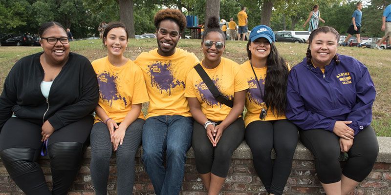 Students sitting on a wall.