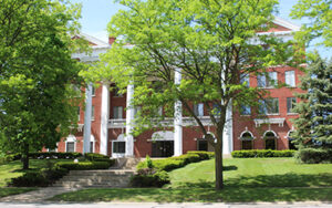 A brick building with white columns.