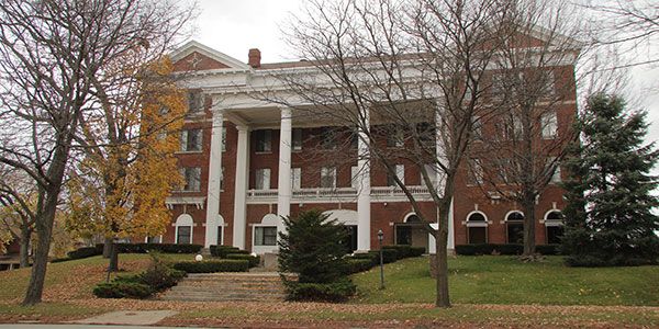 A brick building with white columns.