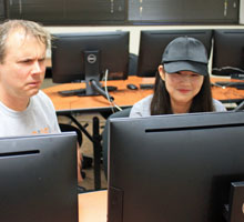 A student and a professor working on the computer.