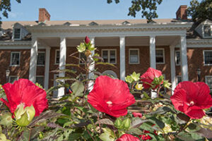 A photo of Wesley Hall with red flowers in the foreground.