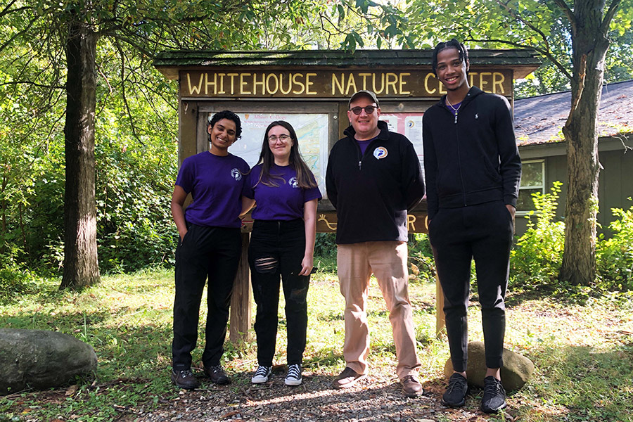 Whitehouse Nature Center employees and director Jason Raddatz posing in front of the Whitehouse Nature Center sign.