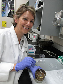 A professor wearing a lab coat and gloves.