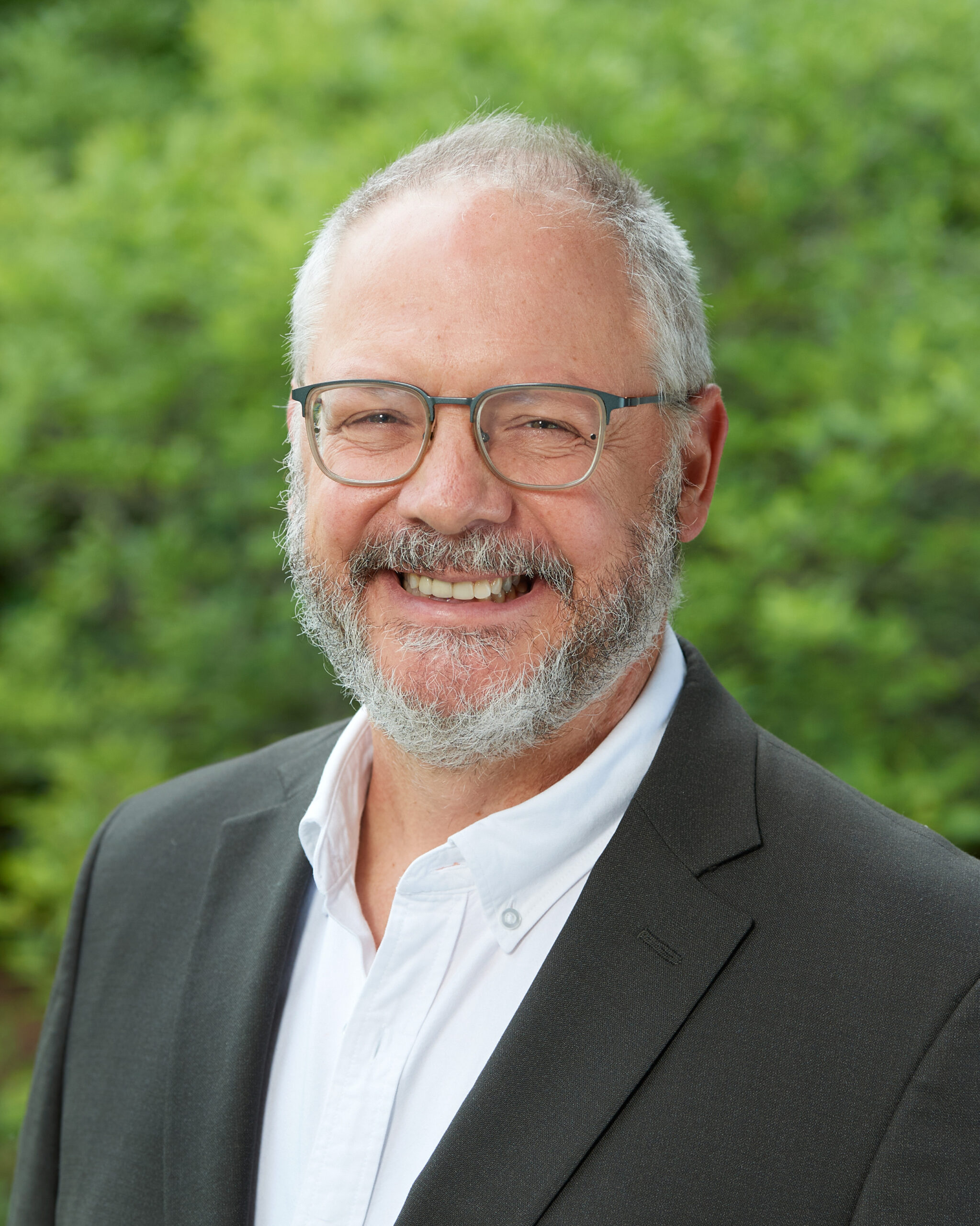 A professional headshot of Thom Wilch.