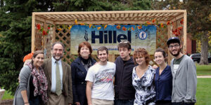 A group of people in front of a banner that says, "Hillel."