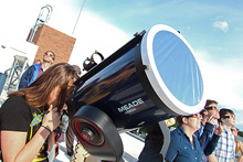 Community members using a telescope.