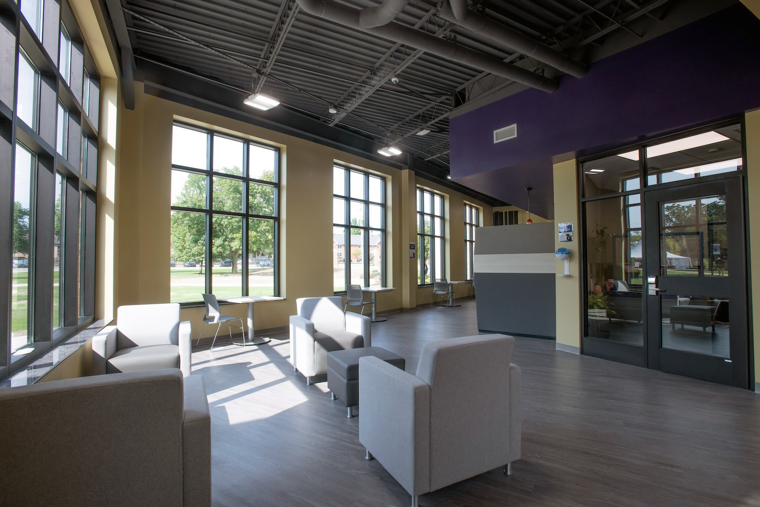 Interior of Serra fitness center expansion featuring comfortable seating and glass doors