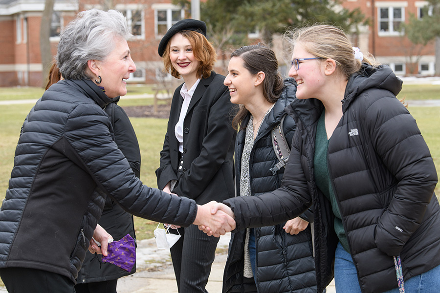 Joey Miller, '75, chair of the Albion College Board of Trustees, with Albion students, March 2022.