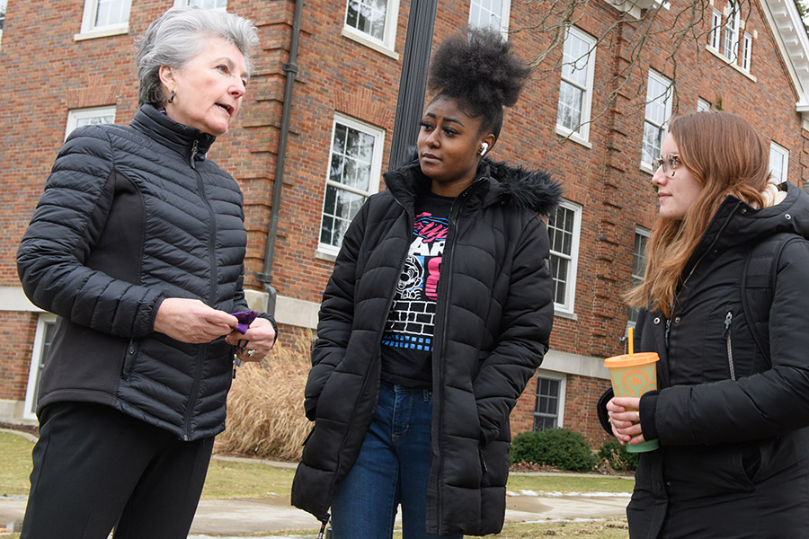 Joey Miller, '75, chair of the Albion College Board of Trustees, with Albion students, March 2022.
