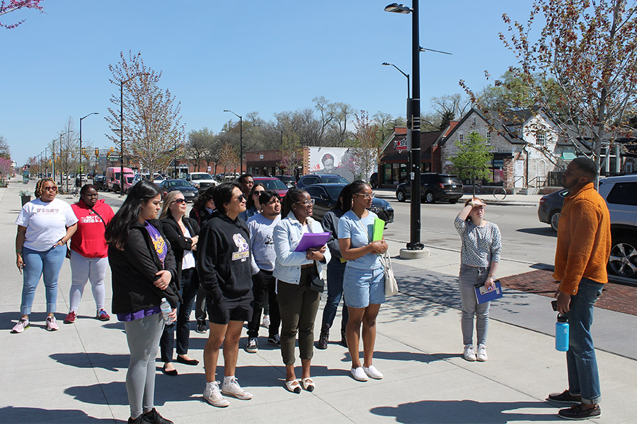 Albion students standing in downtown Detroit listening to a presenter.