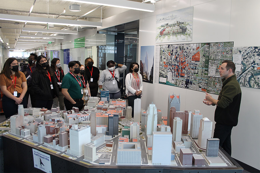 Albion College students behind scale models of Detroit buildings listening to a speaker.