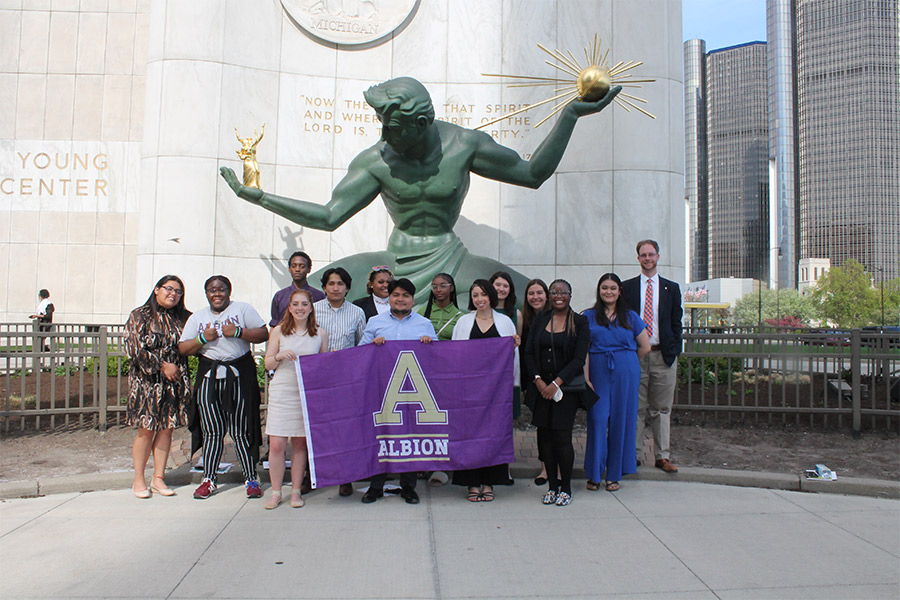 Albion College students posing in front of the Spirit of Detroit statue.