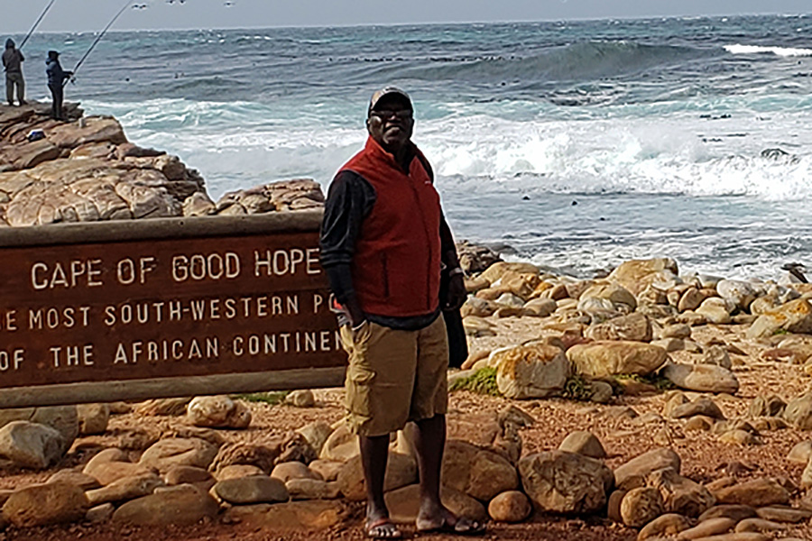 A photo of Ola Olapade in front of the ocean.